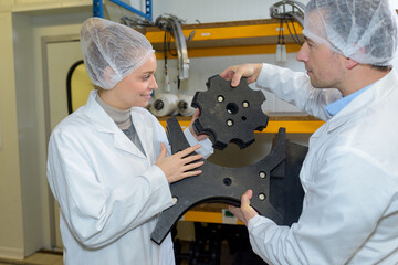 consumption factory workers holding machine part