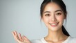 © Generative AI - Happy Asian woman presenting or showing open hand palm with copy space for product on white background : Generative AI