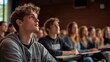 © Pojjanee - Engaged Minds in the Lecture Hall: A young man listens intently in a university lecture, surrounded by his equally attentive peers, capturing the essence of higher education.