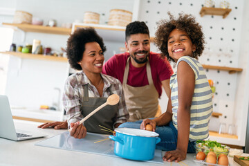 Wall Mural - Happy african american family preparing healthy food in kitchen, having fun together on weekend