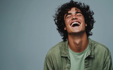 A handsome man wearing bright clothes and smiling and laughing against a solid green background. Produced using generative AI.