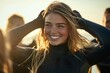 © Maxim Borbut - A carefree young female surfer on the beach in a wetsuit during the summer