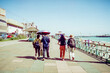 © Thomas - A group of people walking in a line on a promenade