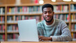 © Oscar - Young male student studying with a laptop in a library