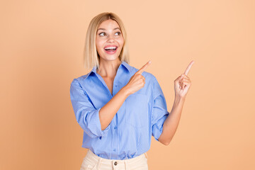 Sticker - Photo of cheerful pretty lady dressed formal shirt showing two fingers looking empty space isolated beige color background