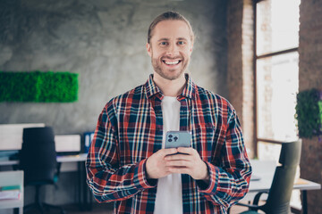 Sticker - Photo of nice young man company worker use smart phone wear checkered shirt modern loft office indoors