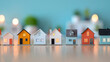 © Novi - Colorful miniature house models lined up on a wooden table