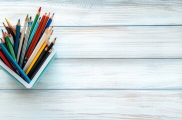 Canvas Print - Colored Pencils in a Container on White Wooden Background