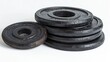 © Nottenaj - A set of weight plates of various sizes neatly stacked on a white background, creating a visually appealing composition.