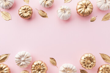 Wall Mural - Stylized white and gold decorative pumpkins and golden leaves border on a pale pink background for autumn and Thanksgiving cards.