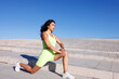 © Mia_Bon - A close-up view of a young mixed race woman warming up in front of stairs outdoors