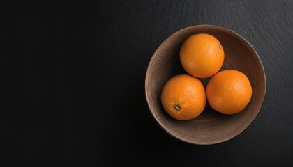 Wall Mural - orange in a bowl on a black background, top view, copy space 