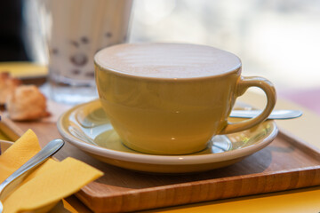 Wall Mural - cup of coffee,Yellow cup with coffee, cup of coffee placed on wooden table, Tasty coffee in a cup on wooden table, close up