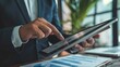 © Sompoch - Businessman using tablet analyzing sales data and financial report, business growth graph chart.