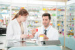 © ultramansk - team man and woman pharmacist inspects a medication bottle, ensuring accuracy in prescription filling. pharmacists in patient safety and careful medication handling. operations in retail pharmacy.