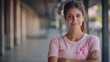 © keetazalay - A striking image of a strong woman standing confidently with her arms crossed wearing a pink ribbon and looking directly at the camera her expression is one of determination and pride symbolizing her