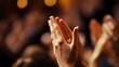 © sarana - Clapping Hands: Hands clapping with a blurred audience in the background.