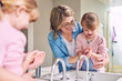 © peopleimages.com - Mother, child and washing hands in bathroom for cleaning, help and learning. Mom, young girl and hygiene at home with soap, foam bubbles and support in family with care and development for growth