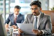 © N7 - Indian Manager Reviewing Reports - An Indian manager reviewing business reports during a meeting.