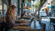 © PaulShlykov - Israel relaxed woman in her 40s working on laptop at coffee place in city.