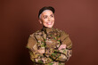 © deagreez - Photo of confident good mood retired woman wear camouflage arms crossed looking empty space isolated brown color background