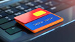 © Aris Suwanmalee - A red and blue credit card sits on a black laptop keyboard.
