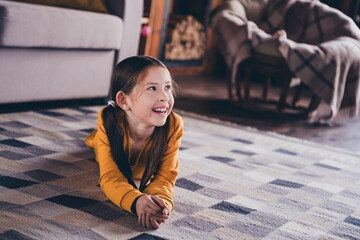 Sticker - Full length photo of charming little girl lying floor look empty space dressed orange garment spend pastime spacious house indoors room