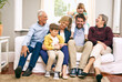© peopleimages.com - Family, laughing and happy in house for relax, bonding and support with generations, love and care. Grandparents, father and girl in living room for comfort, relationship or visit together on weekend