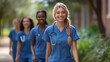 © aekkorn - Diverse team of medical students young women in scrubs walk together on a university hospital campus.