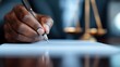 ©  lukaPixMedia - A close-up of a hand signing a document with a pen, the background features justice scales, symbolizing legal actions and authority in a professional office setting.