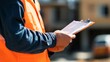 © NATTAWUT - Construction manager holding a safety checklist while overseeing site operations