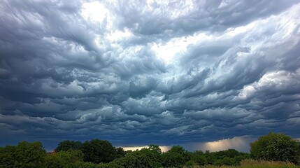 Wall Mural - a sky with thick, gray clouds indicating an approaching storm, creating a moody atmosphere