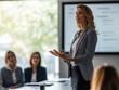 © Frank Gärtner - Female executive is delivering a presentation to her coworkers in a meeting room