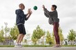 © Seventyfour - Side view of senior smiling woman and man in sportswear doing squat jumps passing ball