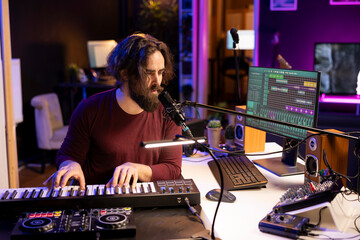 Leinwandbilder - Creative musician recording new tunes with microphone and midi controller, playing piano keys in home studio. Skilled composer producing music with modern electronic keyboard and audio gear.