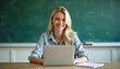 © ahmed - Radiant white blonde female teacher at desk with laptop for World Teachers' Day