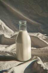 Sticker - A bottle of milk placed on a bed, possibly for morning use