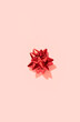 © Darya Lavinskaya - Christmas postcard wallpaper with red bow on pink in minimal style. Xmas holiday background