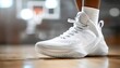 © Arbystudio - White Basketball Shoe with Perforated Design on Wooden Court