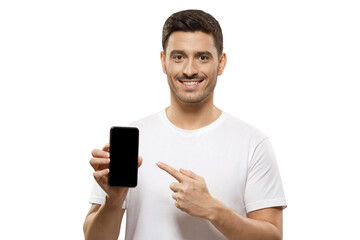 young handsome man in white t-shirt holding phone, pointing to blank screen with finger, recommendin