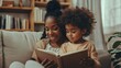 © Lucija - african american mother reading book with daughter on living room sofa