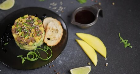 Canvas Print - Traditional tuna and mango tartare on black ceramic plate