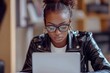 © khalid_spk - A focused young woman working on her laptop in a modern well-lit office