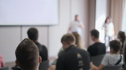 Wall Mural - Group of people attentively listening during a presentation in a professional conference room setting. Ideal for concepts of learning, teamwork, and corporate training.