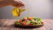 © Ant - Hand pouring olive oil over a fresh salad, healthy fats for brain health, Mediterranean diet healthy eating