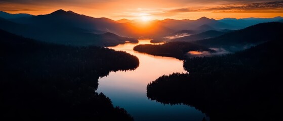 Wall Mural -  The sun sets over mountains, framing a river in the foreground Trees line both banks