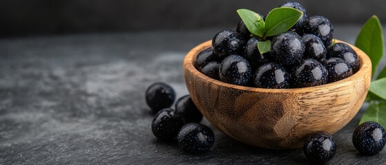 Wall Mural -  A wooden bowl, brimming with blackberries, sits atop a green leaf on a gray counter Nearby, another identical bowl holds more blackberries