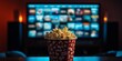 © Valerii Dekhtiarenko - Popcorn bucket with a playful design, front and center, against a blurred background of a streaming menu on TV