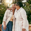 © Flashizzle/peopleimages.com - Senior mother, black woman and hug outdoor for love, care and laughing together in nature. African parent, adult daughter and embrace for connection, support and happiness of funny family at reunion