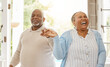 © Flashizzle/peopleimages.com - Black couple, retirement and dance in home for love, happiness and trust in relationship. Elderly man, wife and holding hands for care with bonding, fun and excited for milestone with celebration